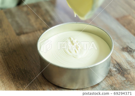 製作稀有起司蛋糕的過程:將麵糊倒入模具中 製作稀有起司蛋糕的過程:將麵糊倒入模具中 69294371