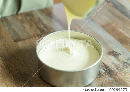 製作起司蛋糕的步驟食譜將麵糊倒入模具中 製作起司蛋糕的步驟食譜將麵糊倒入模具中 69294375