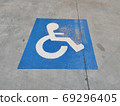 Blue sign on the asphalt about disabled parking 69296405