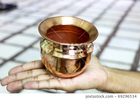 Indian copper shining bowl on a person's hand 69296534