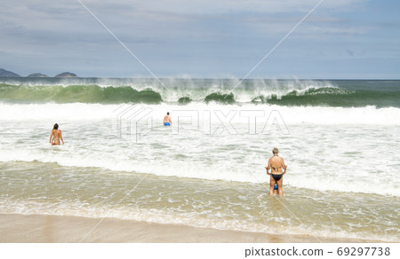 Rio de Janeiro, Brasil- February 28, 2020: Citizens swim and sunbathe on the beach of Copacabana Rio de Janeiro, Brasil- February 28, 2020: Citizens swim and sunbathe on the beach of Copacabana 69297738