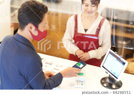 Male customers and female clerk paying cashless at infectious disease prevention stores Male customers and female clerk paying cashless at infectious disease prevention stores 69298551