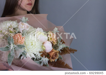 Portrait of long-haired brunette girl with beautiful summer bouquet, gift or congratulation concept. 69299045
