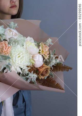 Portrait of long-haired brunette girl with beautiful summer bouquet, gift or congratulation concept. 69299046