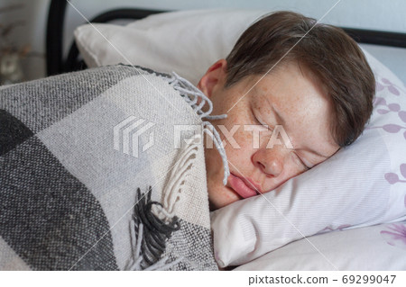 Mature brunette woman sleeping in bed under plaid blanket, illness or cold concept , selective focus Mature brunette woman sleeping in bed under plaid blanket, illness or cold concept , selective focus 69299047