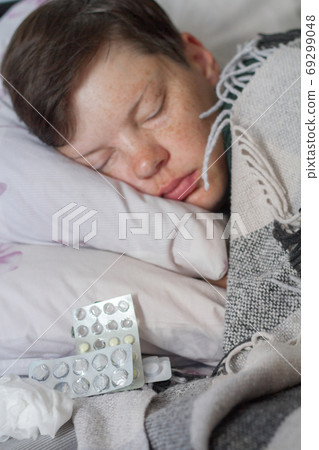 Mature brunette woman sleeping in bed under plaid blanket, illness or cold concept , selective focus Mature brunette woman sleeping in bed under plaid blanket, illness or cold concept , selective focus 69299048