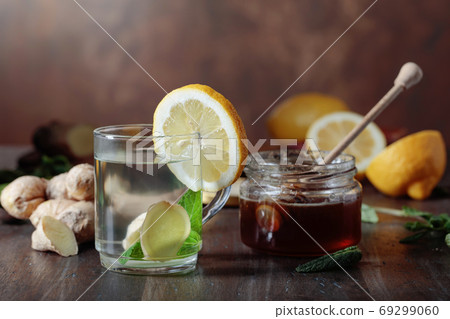 Ginger tea with honey , lemon and mint on old wooden table . 69299060