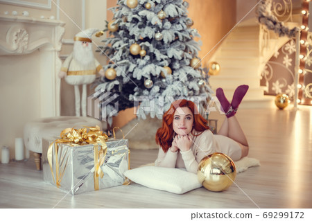 Happy young lady with curlu hair gifts by the 69299172