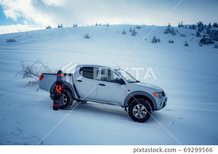 Pickup truck on road, Beautiful winter road under snow mountains. 69299566