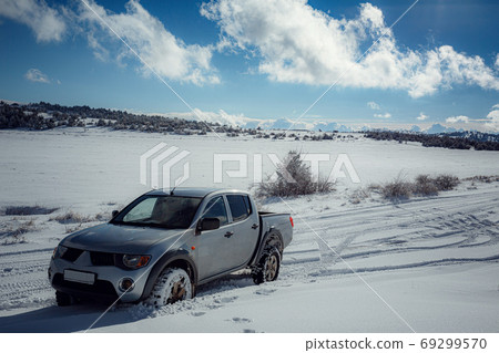 Pickup truck on road, Beautiful winter road under snow mountains. Pickup truck on road, Beautiful winter road under snow mountains. 69299570