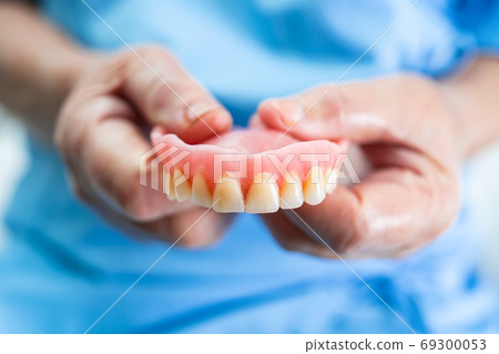 Asian senior or elderly old woman patient holding to use denture Asian senior or elderly old woman patient holding to use denture 69300053