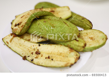 On plate are cooked zucchini with seasoning and garlic On plate are cooked zucchini with seasoning and garlic 69300413