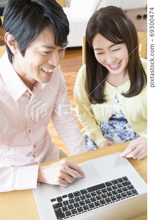 A couple looking at a laptop computer A couple looking at a laptop computer 69300474