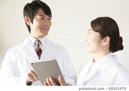 Doctor and nurse looking at electronic chart 69301470