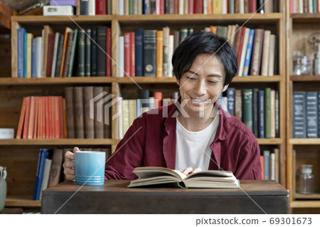 A young man reading a book A young man reading a book 69301673
