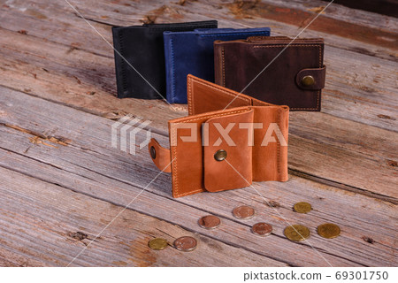 Hand made leather man wallet on wooden background Hand made leather man wallet on wooden background 69301750