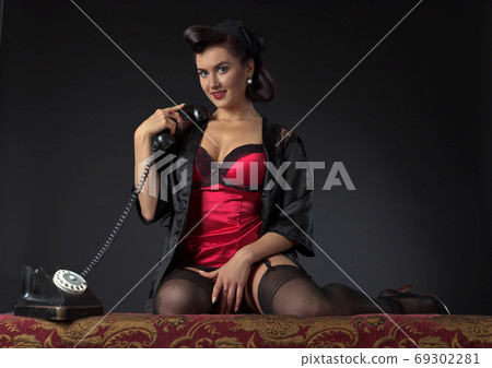 Beautiful woman speaking via vintage phone. 69302281