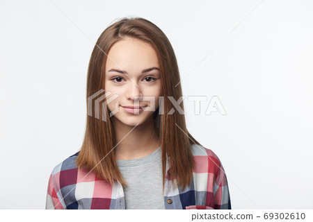 Smiling relaxed teen girl looking at camera Smiling relaxed teen girl looking at camera 69302610