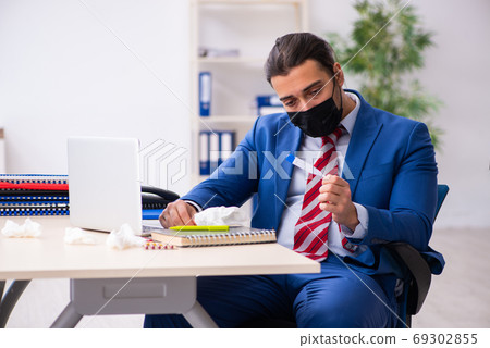 Sick male employee suffering at workplace from coronavirus 69302855
