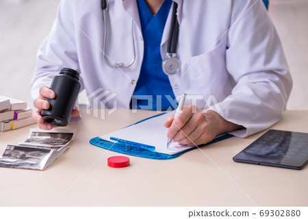 Old male doctor therapist working in the clinic Old male doctor therapist working in the clinic 69302880
