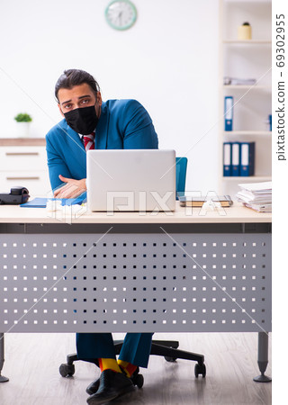 Sick male employee suffering at workplace from coronavirus Sick male employee suffering at workplace from coronavirus 69302955