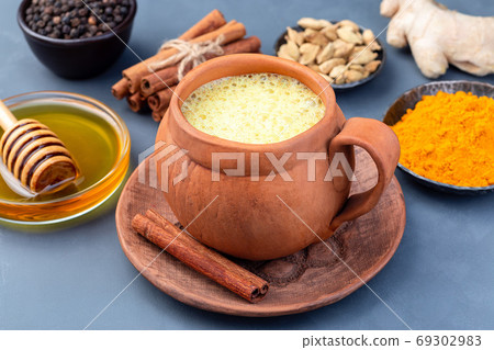 Yellow moon milk with turmeric in clay cup Yellow moon milk with turmeric in clay cup 69302983