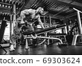 Attractive tall muscular bodybuilder doing heavy deadlifts in moder fitness center. 69303624