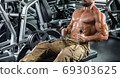 Attractive tall muscular bodybuilder doing heavy deadlifts in moder fitness center. 69303625