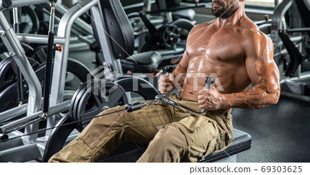 Attractive tall muscular bodybuilder doing heavy deadlifts in moder fitness center. 69303625