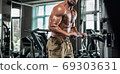 Attractive tall muscular bodybuilder doing heavy deadlifts in moder fitness center. 69303631