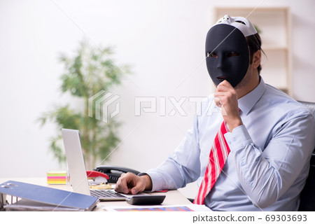 Male employee with mask in hipocrisy concept 69303693