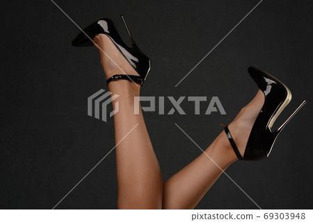 Slender female legs in a fetish shoe with extremely high heels. Slender female legs in a fetish shoe with extremely high heels. 69303948