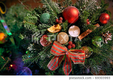 Christmas wreath handmade on a wooden background. Festive lights of garland. New Year's interior decoration 69303993