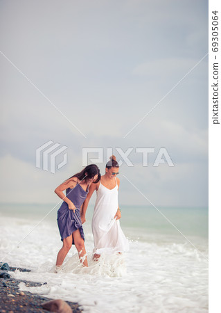 Young women in white on the beach Young women in white on the beach 69305064