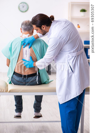 Old man visiting young male doctor 69305307