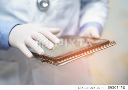 Doctor holding digital tablet to search data for treat patient in nursing hospital ward Doctor holding digital tablet to search data for treat patient in nursing hospital ward 69305458