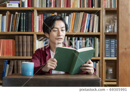 A young man reading a book 69305991