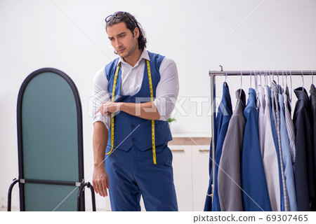 Young male tailor working at workshop Young male tailor working at workshop 69307465