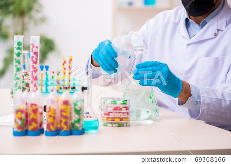 Young male chemist in drug synthesis concept 69308166