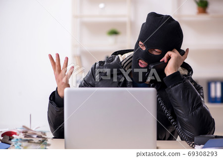 Young male burglar in the office 69308293