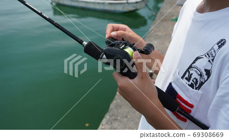 A fishing rod held by a boy fishing A fishing rod held by a boy fishing 69308669