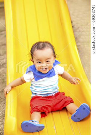Big frolic boy on the slide in the park 69308743