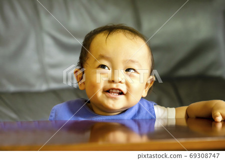 A boy who looks up in the room and looks happy. 69308747