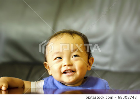 A boy who looks up in the room and looks happy. 69308748