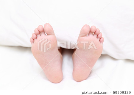 赤腳的一個女孩在床上睡覺 69309329