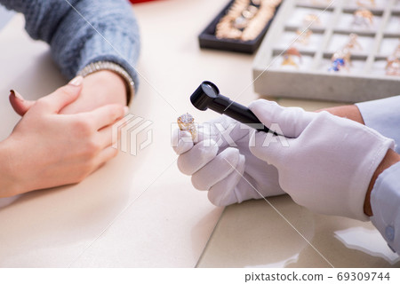 Male jeweler and female client at store 69309744