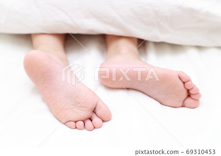 赤腳的一個女孩在床上睡覺 69310453