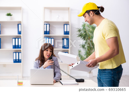Young male courier delivering pizza to the office Young male courier delivering pizza to the office 69310665