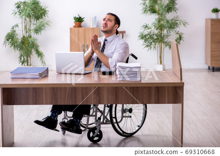 Young disabled employee suffering at workplace Young disabled employee suffering at workplace 69310668