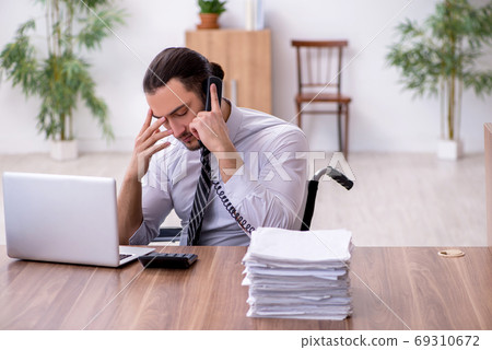 Young disabled employee suffering at workplace Young disabled employee suffering at workplace 69310672